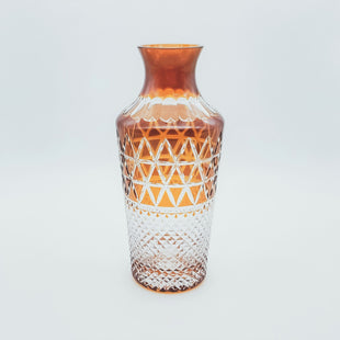 Colored amber cut glass bottle with chalazine on the edge of the scales