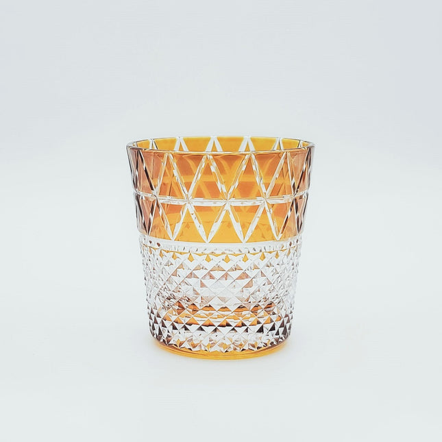 Colored amber cut glass cup with chalazine on the edge of the scales